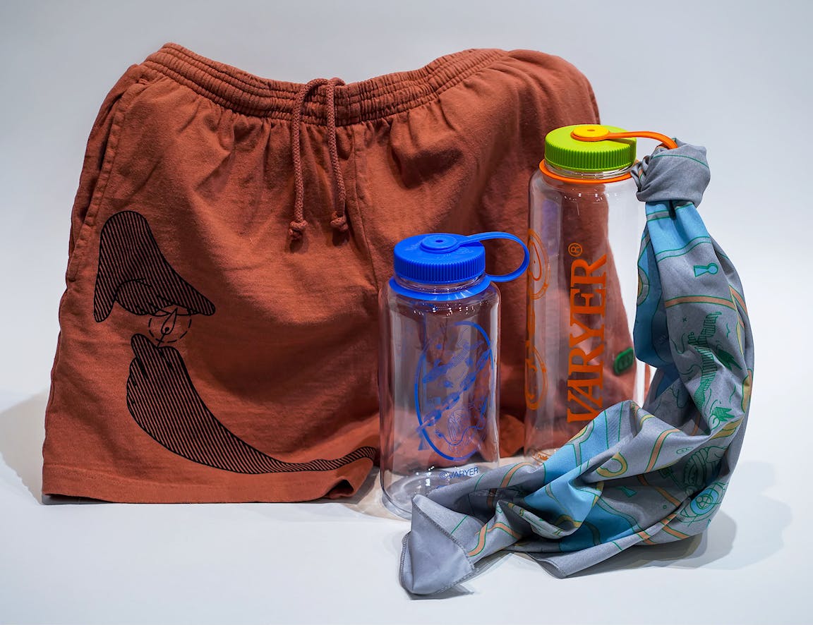 A photo of two water bottles, terra-cotta colored shorts, and a blue bandana.